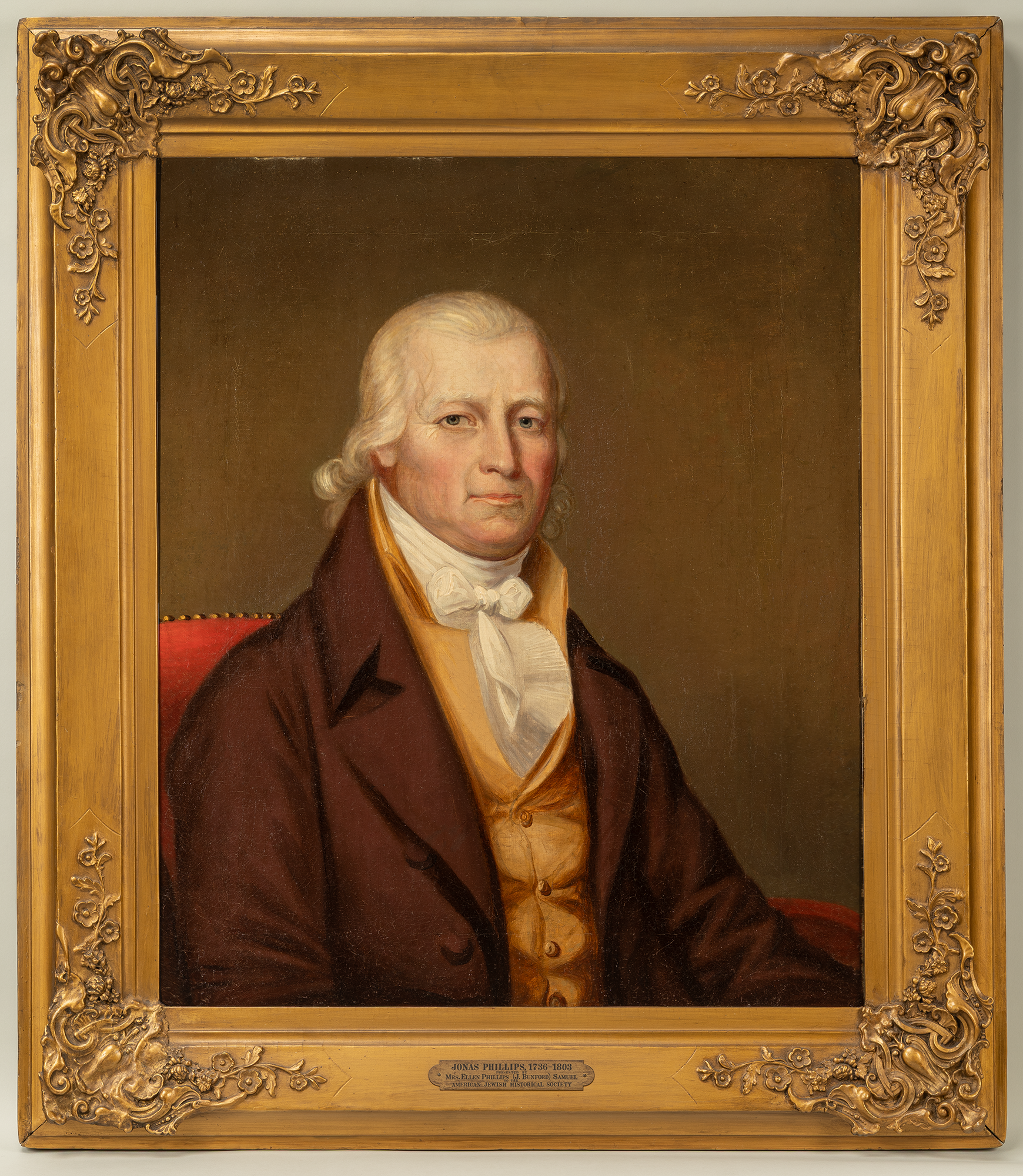 A painted photo of an man from the 18th century inside an elaborate gold frame