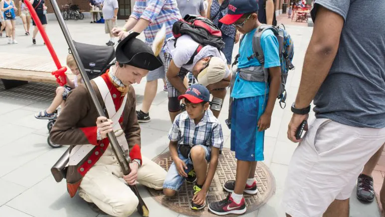 Children interacting with a museum reenactor.