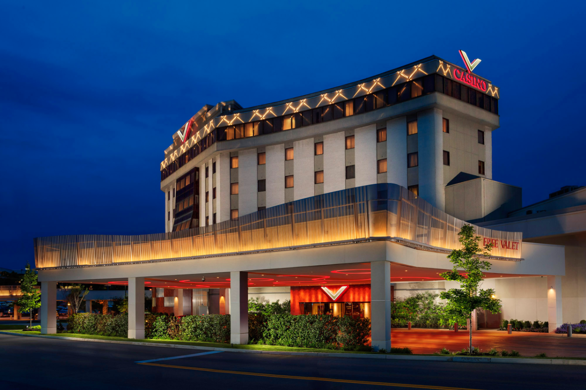 The exterior of the Valley Forge Casino and Resort with red and orange lights and details against a deep blue night sky.