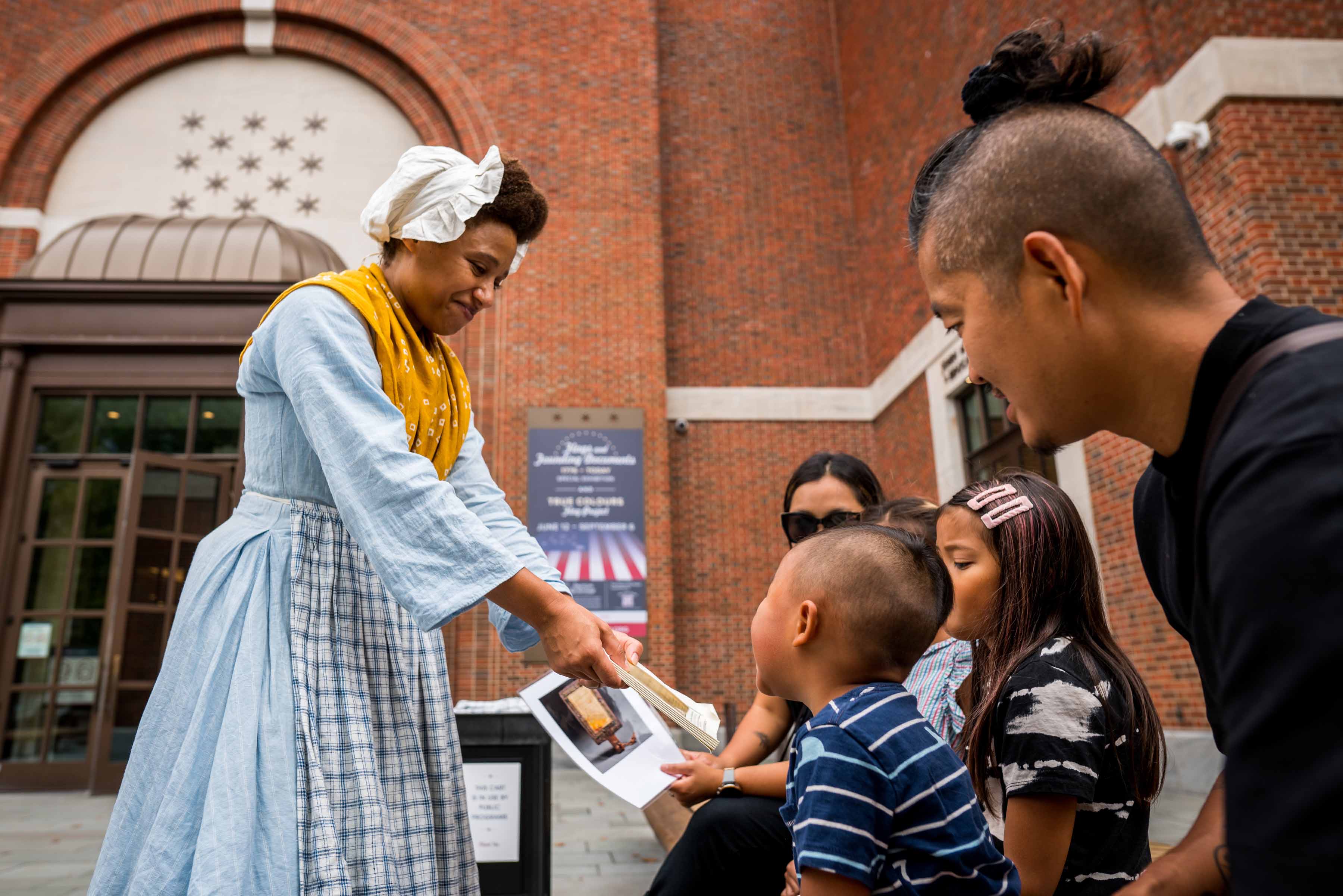 Kalela Williams interacts with young guests at a Discovery Cart on the Museum's Plaza as part of our Meet the Revolution series.