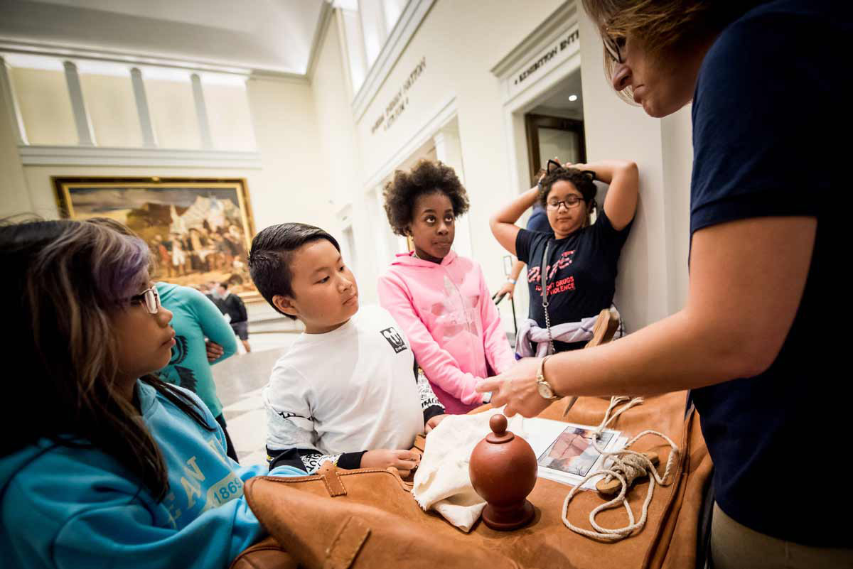 Children interacting with a discovery cart about Washington's Tent