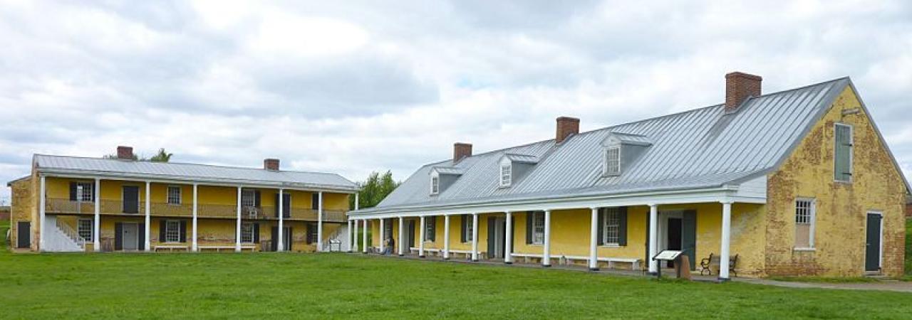 This image shows two yell buildings with gray roofs and white details that are part of Fort Mifflin.