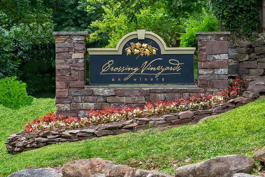 This image shows the stone and black sign at the entrance of Crossing Vineyard and Winery.