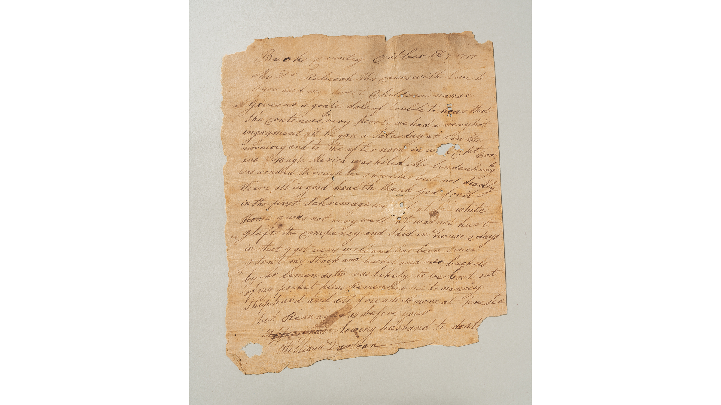 Sheet of paper filled with cursive writing; paper shows signs of damage