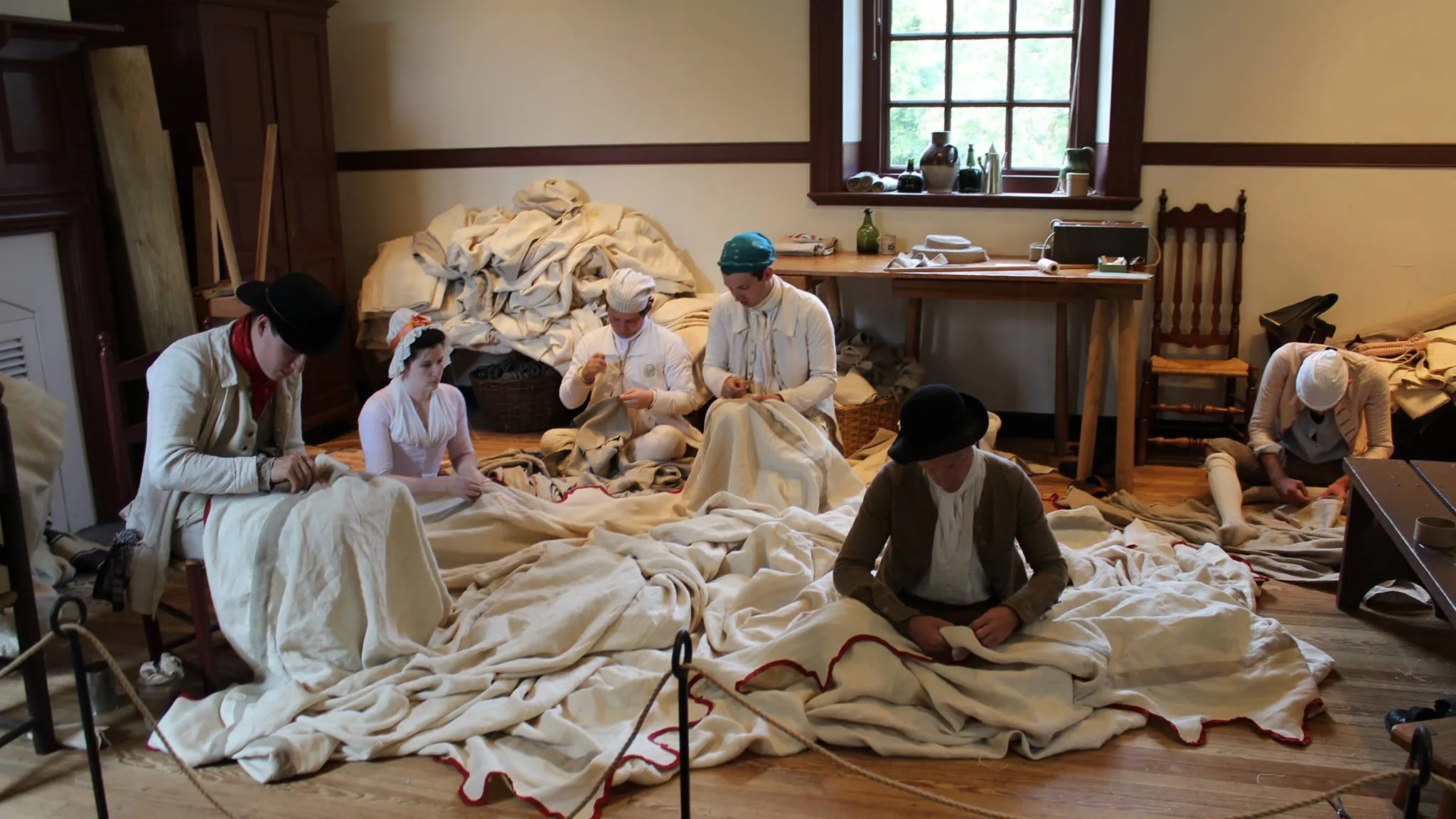 Staff members from the Museum of the American Revolution and Colonial Williamsburg work on sewing the Museum's replica of George Washington's headquarters tent