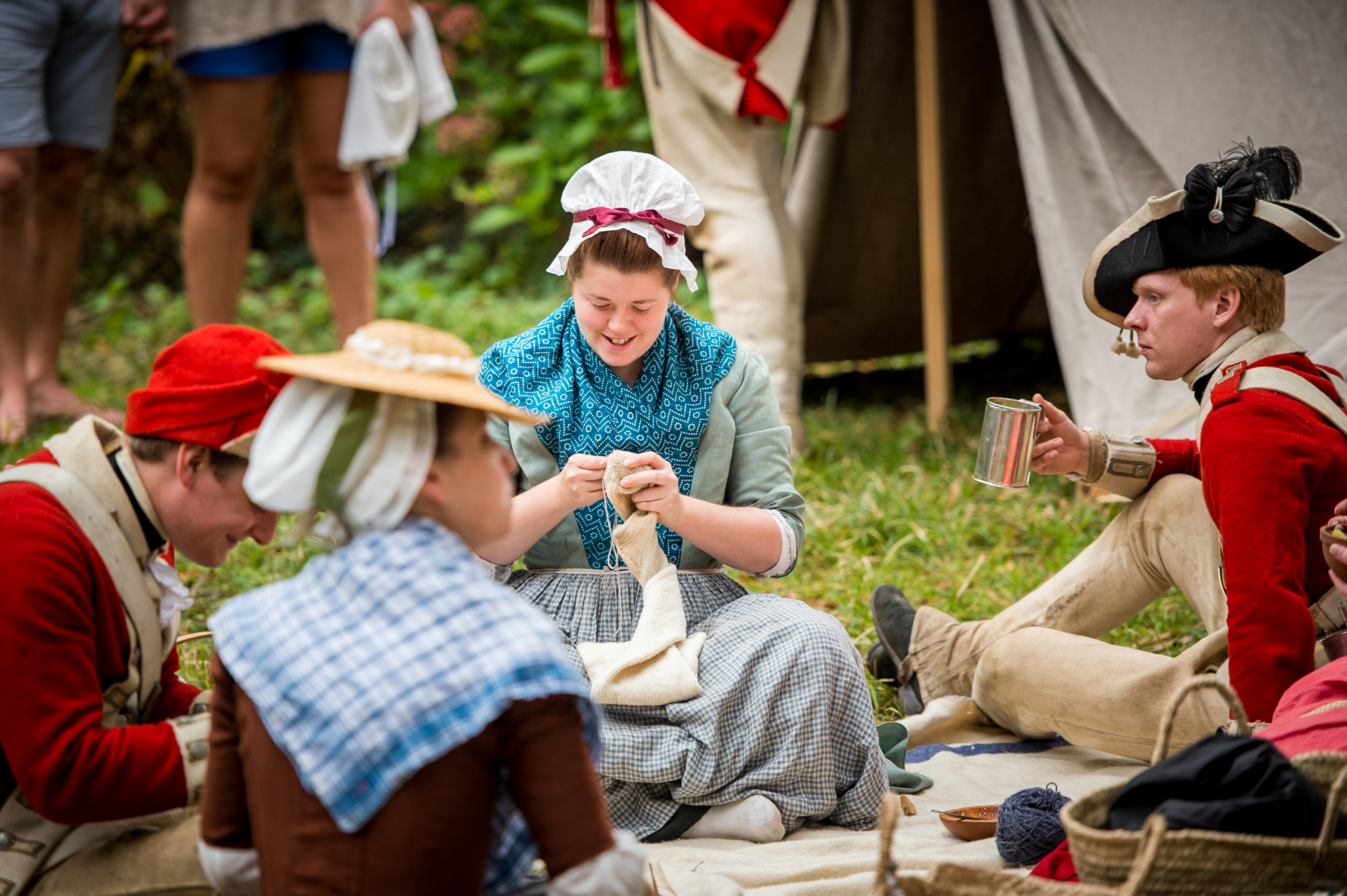American Revolution historical demonstrators interact in a field.
