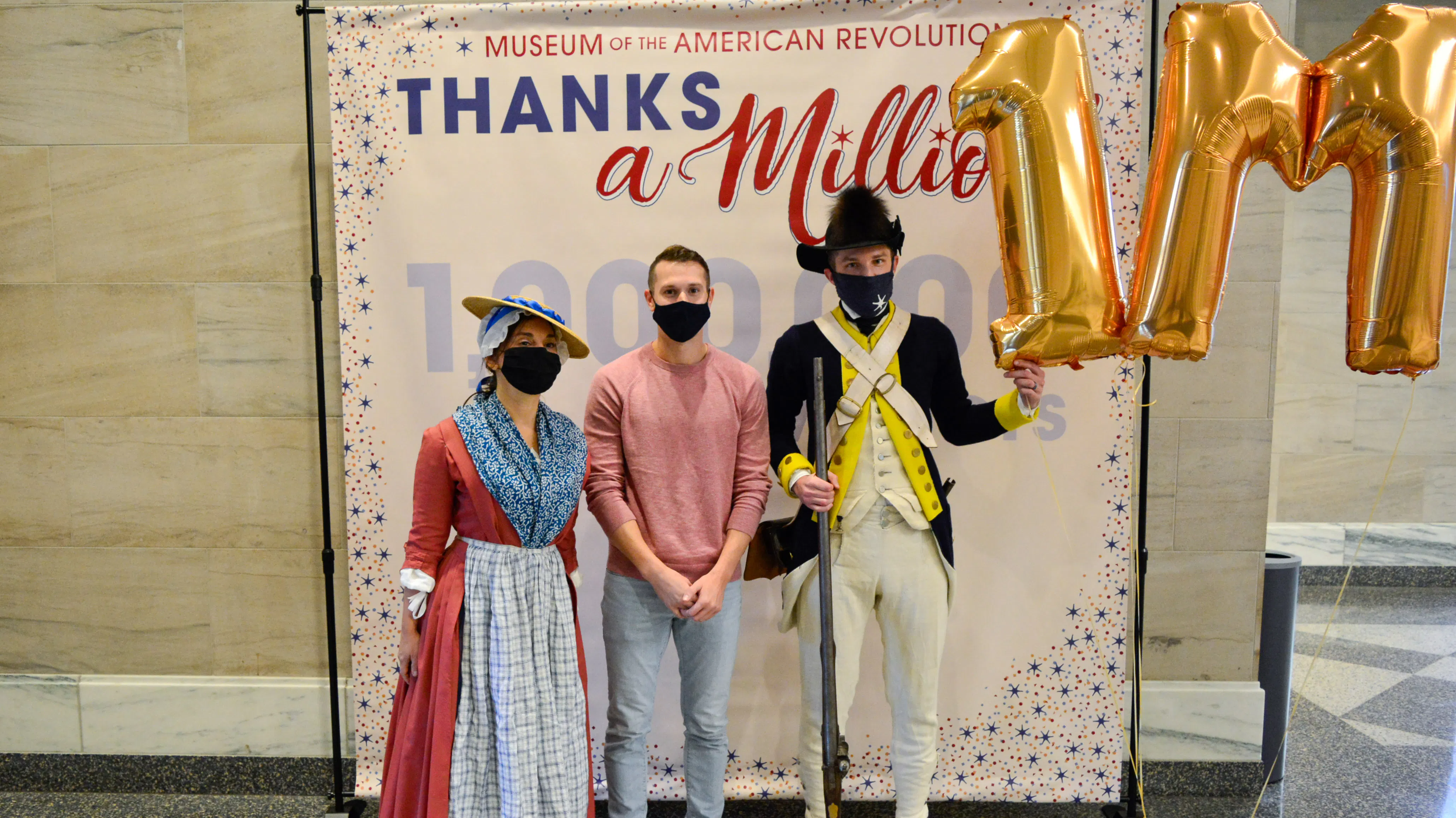 Millionth Visitor Jacob B. poses with costumed interpreters.