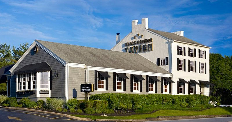 Image of the Black Powder Tavern that includes an 18th century white building as part of the structure.