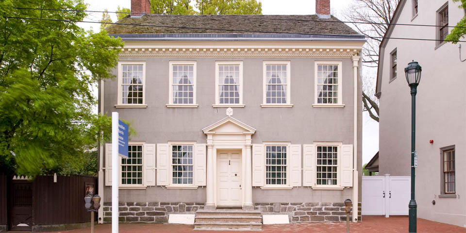 This image shows a grayish brick house that is the Germantown White House in northwest Philadelphia.